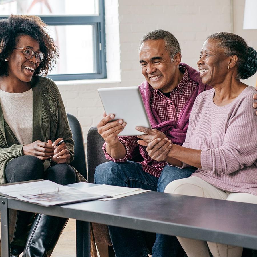 elderly Black couple  consulting with a female Black gerontology worker