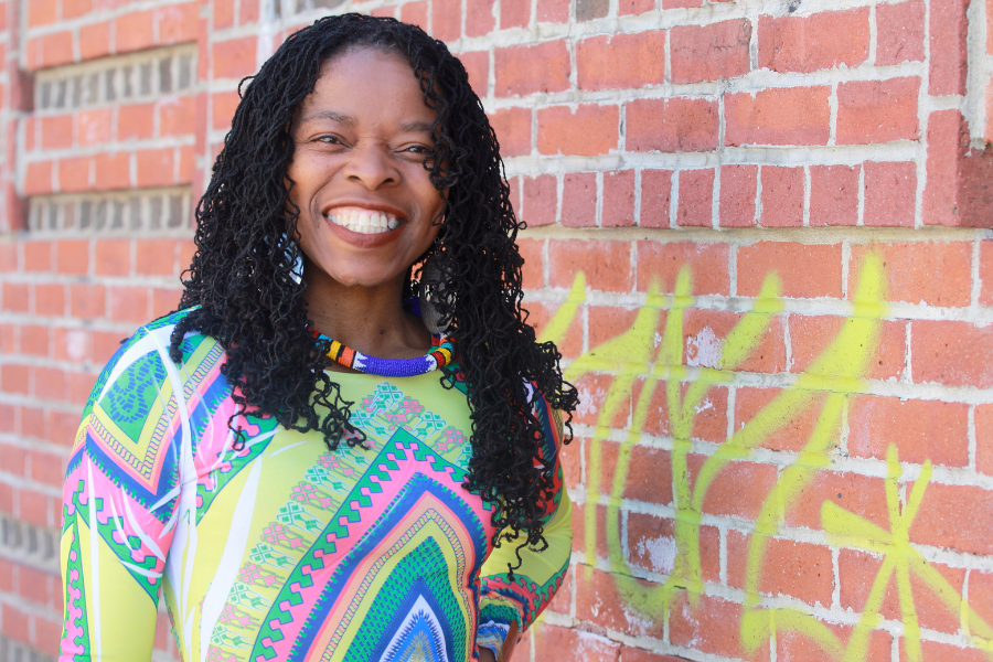 Shaumba-Yandje standing next to a brick wall